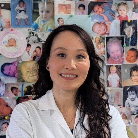 Dr. Florence Lim in front of baby wall.